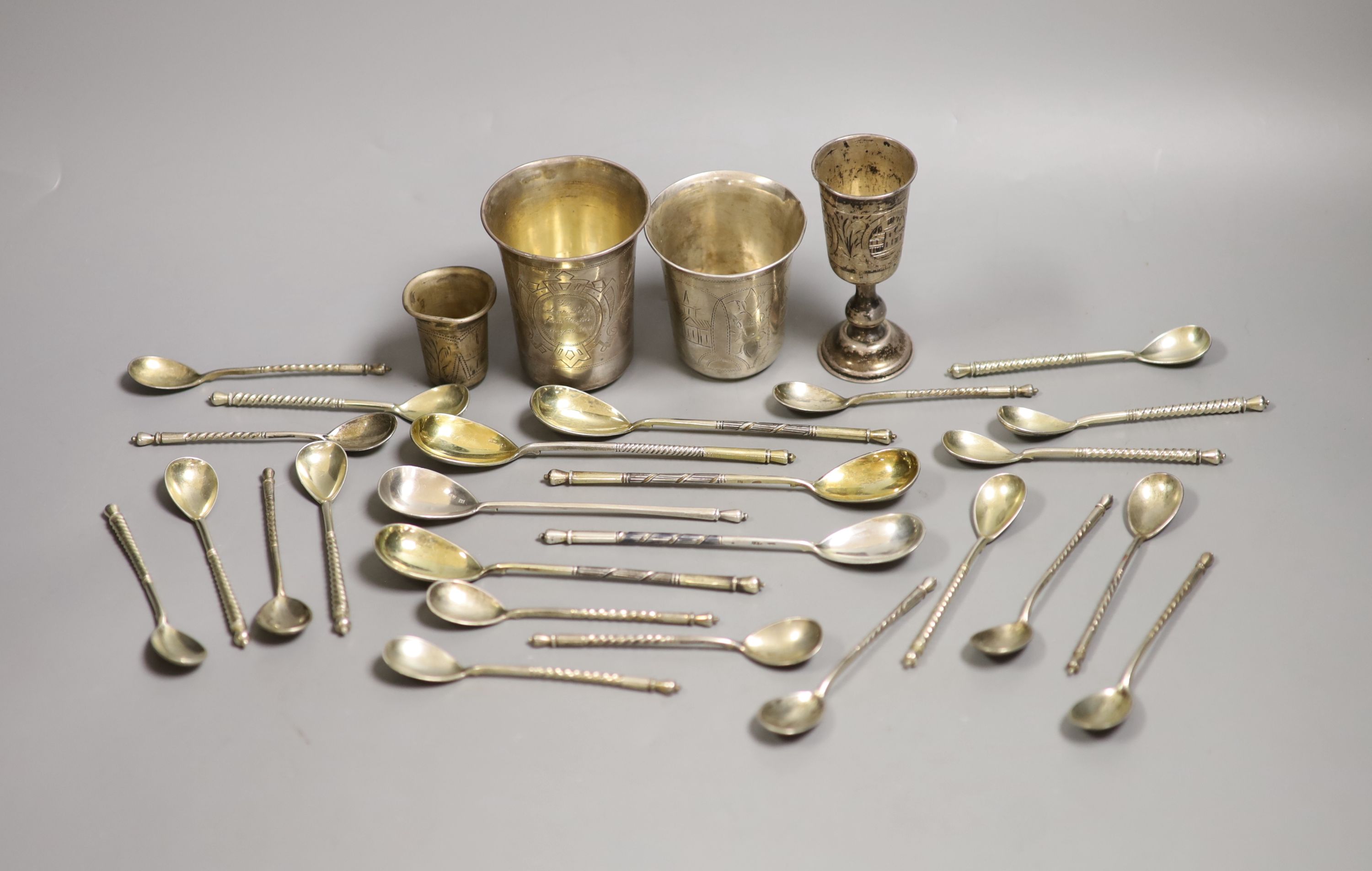 Four assorted 19th century Russian 84 zolotnik small beakers, largest 93mm and twenty five similar tea or coffee spoons including a set of eight with niello decoration